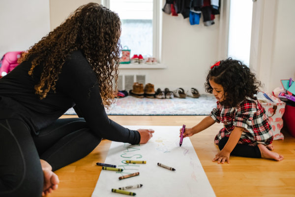 A mother draws with her daughter during a documentary family photography session in San Francisco, CA