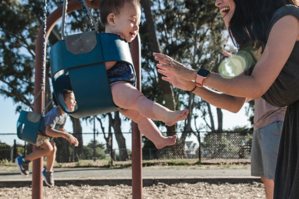 A mom pushes her son on the swing in Alameda, CA