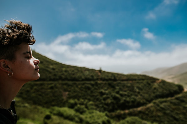 A young girl feels the sun on her face as she hikes in the Golden Gate National Rec Area outside of San Francisco, CA