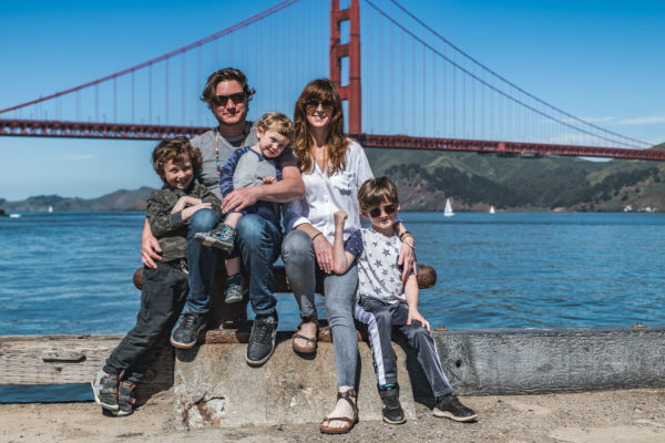 A family poses in front of the Golden Gate Bridge in San Francisco, CA