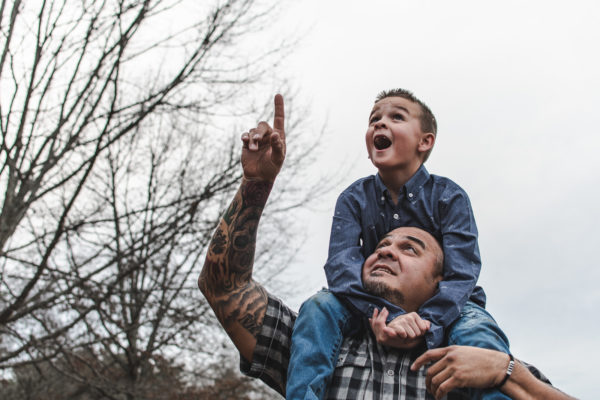 A father holds his son on his shoulders while at the park in Kennesaw, GA