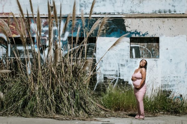 A pregnant woman holds her belly during a maternity shoot in Oakland, CA