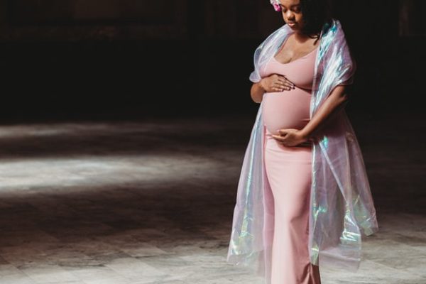 Pregnant woman stands for her maternity photography shoot in Oakland, CA