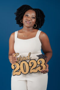 Young senior girl holds a Grad 2023 sign during a senior photo shoot in Emeryville, CA