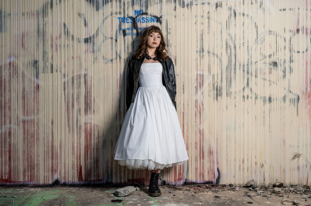 Modern senior portrait with white dress and leather jacket photographed in an urban Bay Area setting